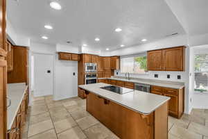 Kitchen featuring a kitchen bar, a wealth of natural light, a center island, and appliances with stainless steel finishes