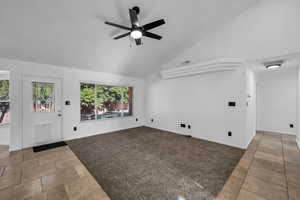 Unfurnished living room featuring ceiling fan, carpet floors, and high vaulted ceiling