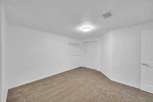 Carpeted spare room featuring a textured ceiling