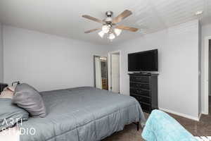 Bedroom with ceiling fan and dark carpet