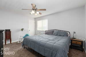 Carpeted bedroom featuring ceiling fan