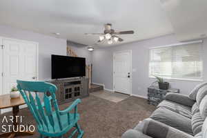 Carpeted living room with ceiling fan