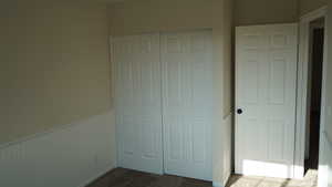 Unfurnished bedroom featuring dark carpet and a closet