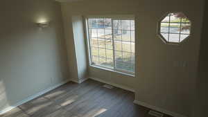 Unfurnished room featuring hardwood / wood-style floors and a healthy amount of sunlight