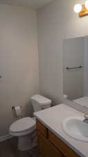 Bathroom with vanity, toilet, and wood-type flooring