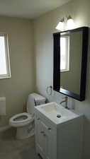 Bathroom with a wealth of natural light, vanity, and toilet