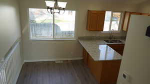 Kitchen featuring dark hardwood / wood-style flooring, sink, a wealth of natural light, and a chandelier