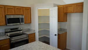 Kitchen featuring light stone countertops and appliances with stainless steel finishes