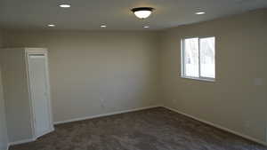 Spare room with dark colored carpet