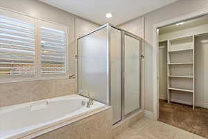 Bathroom featuring tile patterned floors and plus walk in shower