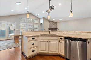 Kitchen with sink, dark hardwood / wood-style flooring, stainless steel dishwasher, an island with sink, and decorative light fixtures