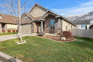 Craftsman inspired home featuring a mountain view, a front lawn, and a garage