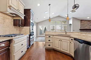 Kitchen with dark hardwood / wood-style floors, sink, lofted ceiling, and stainless steel appliances