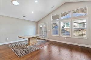 Interior space featuring high vaulted ceiling and dark wood-type flooring