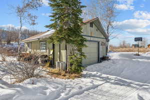 View of snow covered exterior featuring a garage