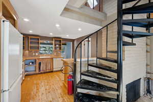 Stairway featuring hardwood / wood-style floors and sink