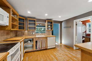 Kitchen with plenty of natural light, tile countertops, sink, and white appliances