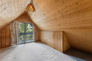 Additional living space with carpet flooring, wood ceiling, lofted ceiling, and wood walls