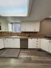 Kitchen with sink, white cabinets, and stainless steel dishwasher