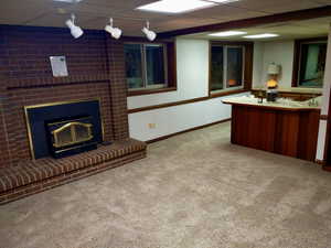 Living room featuring a paneled ceiling, carpet floors, and rail lighting