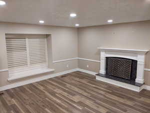 Unfurnished living room with a fireplace and dark hardwood / wood-style floors