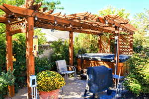 View of patio / terrace featuring a pergola, a hot tub, and grilling area