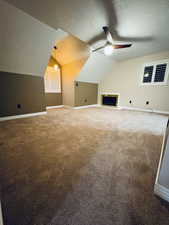 Master Bedroom featuring carpet flooring, a textured ceiling, vaulted ceiling, and ceiling fan