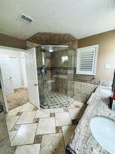 Master Bathroom featuring vanity, a shower with door, and a textured ceiling