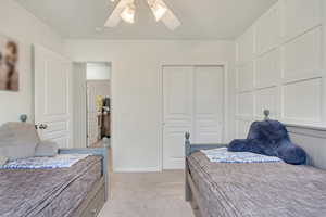 Carpeted bedroom featuring ceiling fan