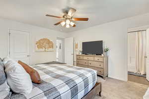 Bedroom featuring ceiling fan, a closet, and light colored carpet