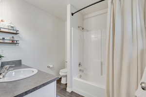 Full bathroom featuring vanity, hardwood / wood-style flooring, toilet, and shower / tub combo with curtain