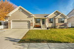 View of front of house featuring a front lawn and a garage