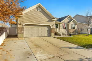 View of front of property with a front yard and a garage