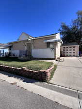 View of front facade featuring an outbuilding and a front lawn