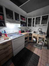 Kitchen with sink, range with electric cooktop, and light tile patterned flooring