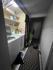 Washroom with washer and dryer, light tile patterned floors, and a textured ceiling