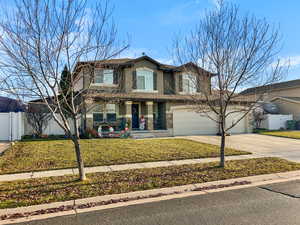 View of front of property featuring a front yard and a garage