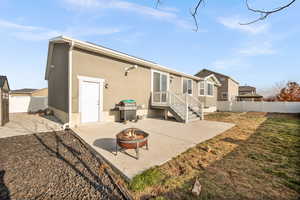 Rear view of house with a patio area and a fire pit