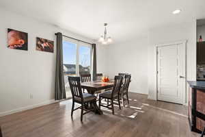 Dining area with a notable chandelier and dark wood-type flooring