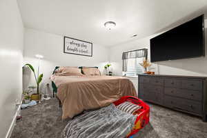 Carpeted bedroom featuring a textured ceiling