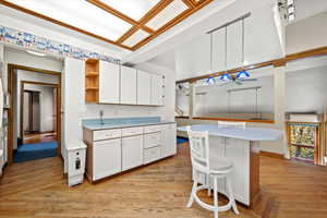 Kitchen with white cabinets, decorative light fixtures, a center island, and ceiling fan