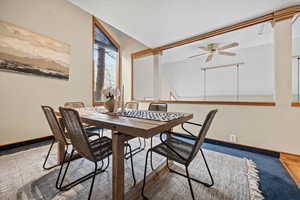 Dining area with hardwood / wood-style flooring, ceiling fan, and vaulted ceiling