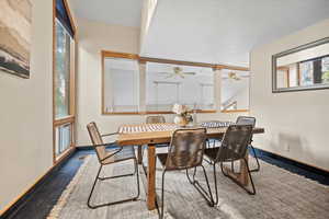 Dining room featuring vaulted ceiling, ceiling fan, carpet floors, and a textured ceiling