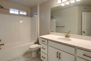 Full bathroom with vanity, shower / bath combination, and toilet