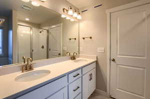 Bathroom with vanity and a shower with door