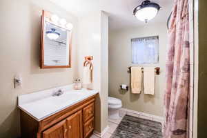 Bathroom with tile patterned floors, walk in shower, vanity, and toilet