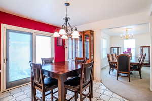 Dining area featuring carpet flooring, ornamental molding, and a chandelier