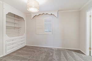 Carpeted empty room featuring crown molding