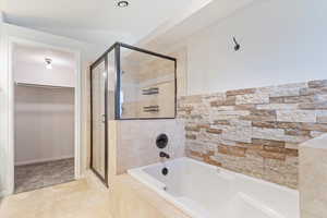 Bathroom featuring tile patterned floors and shower with separate bathtub