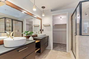 Bathroom featuring tile patterned flooring, vanity, and an enclosed shower